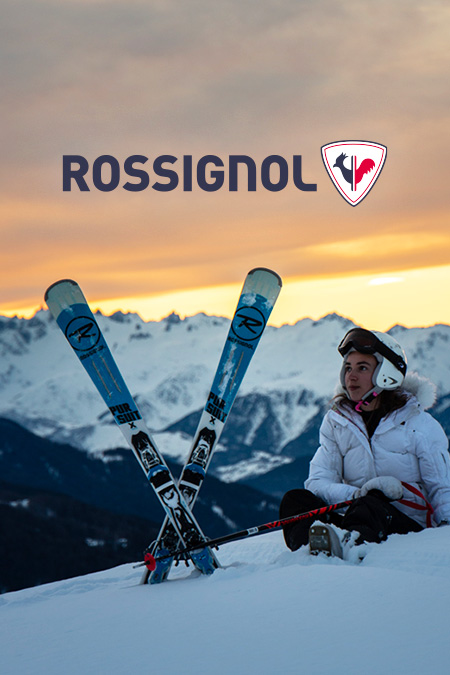 Femme à la montagne faisant une pause avec ses skis rossignol